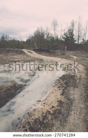 empty country road in spring with perspective and shadows - retro vintage film effect