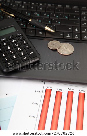 Calculator, laptop and money on the table