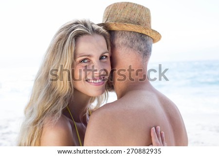 Happy couple hugging each other by the sea at the beach