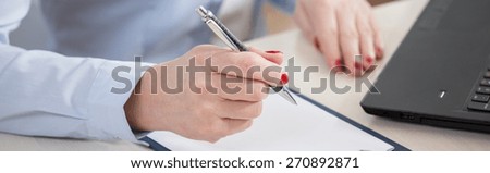 Panoramic view of a pen in the hand of elderly businesswoman