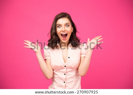 Surprised young woman shouting over pink background. Looking at camera Royalty-Free Stock Photo #270907925