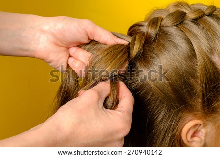 Mother braiding French braid her daughter Royalty-Free Stock Photo #270940142