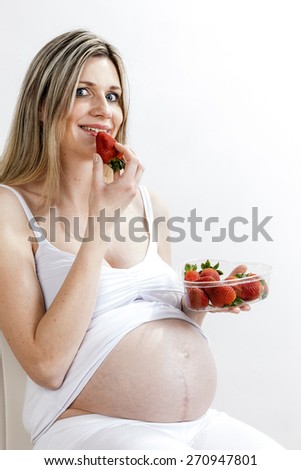 portrait of pregnant woman eating strawberries