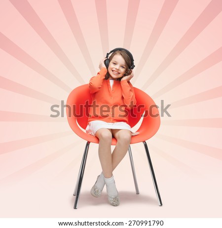 people, leisure, hobby and entertainment concept - happy little girl listening to music in headphones over pink burst rays background