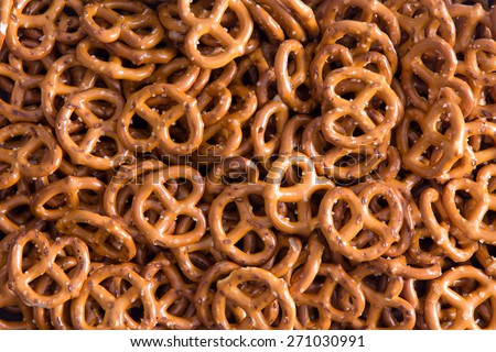 Background texture of salted savory mini pretzels in the traditional looped knot shape in a random heap viewed full frame from overhead Royalty-Free Stock Photo #271030991