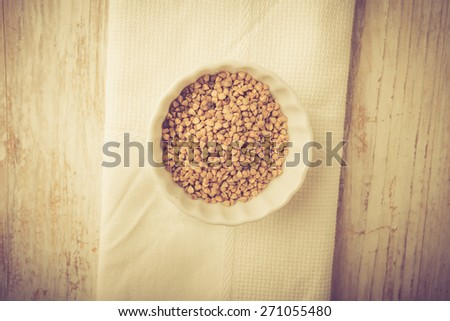 Buckwheat grains in white bowl. Studio shot with vintge mood. Beautiful food photo.