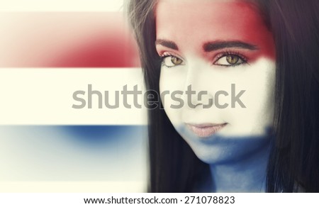 The flag of Netherlands on the face of a smiling woman. / Color effects and custom white balance is added to this photo.