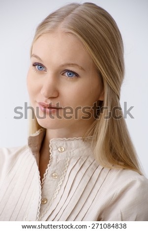 Portrait of young blonde woman with blue eyes, looking away, daydreaming.