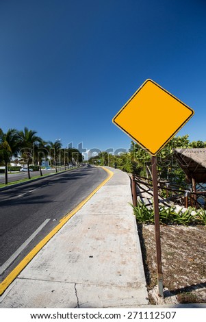 Empty yellow road sign. Tropical street 