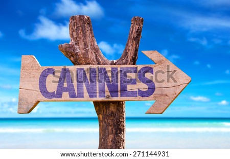 Cannes wooden sign with beach background