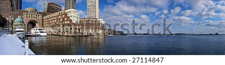 panoramic view of boston harbor with rowes wharf and skyscraper buildings in boston massachusetts on a cloudy winter day