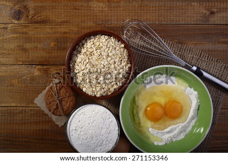 Set of ingredients and appliances for baking with yolk in flour and oatmeal on wooden table top copyspace, horizontal picture