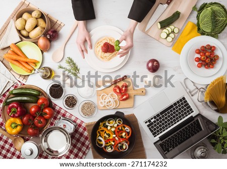 Professional chef's hands cooking pasta on a wooden worktop with vegetables, food ingredients and utensils, top view Royalty-Free Stock Photo #271174232
