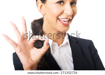 Young businesswoman showing ok sign, looking at the camera
