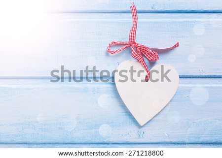 Decorative heart in ray of light on blue painted wooden background. Place for text.