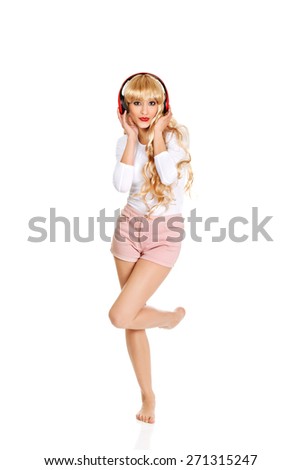 Happy blonde woman dancing and listening to the music.