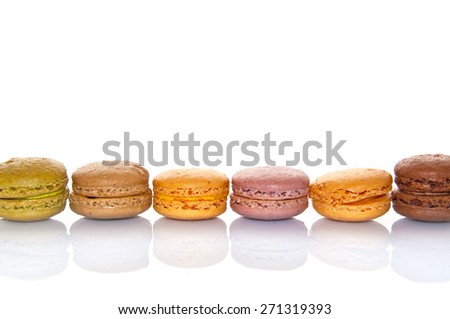Line of pastel colored french macarons, on white background