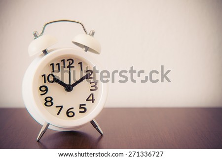 White alarm clock on table - retro effect style