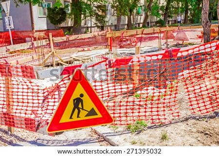 Construction site is protected by several signs and orange fence for safety.