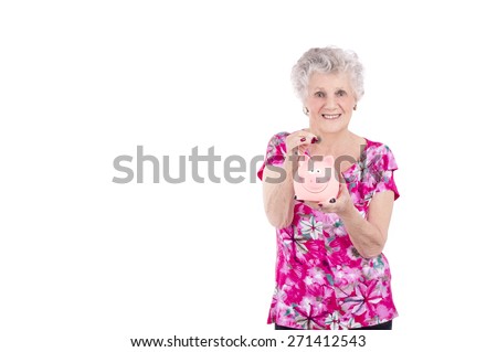 Old woman putting a coin in a piggy bank against a white background