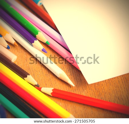 set of colored pencils with white paper. shallow depth sharpness.