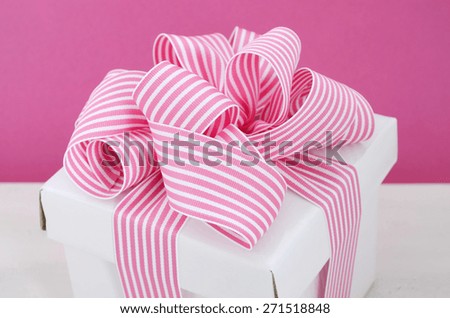 Happy Mothers Day white gift box with pink stripe ribbon in modern pink and white vintage wood table background.