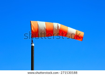 close-up of orange windsock on blue sky background