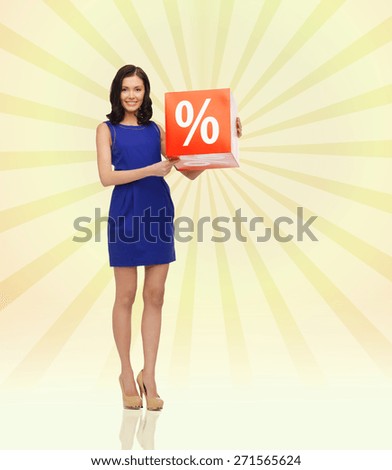 people, business, discount, shopping and consumerism concept - happy young woman in dress with red sale sign over yellow burst rays background