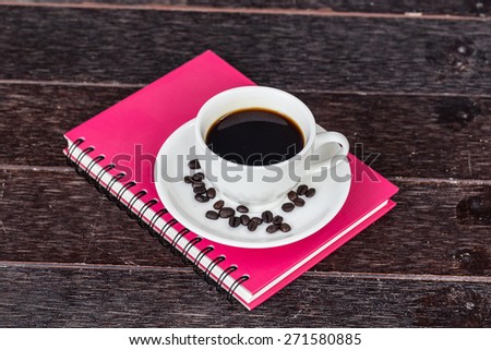 A cup of cafe latte and book on wooden table