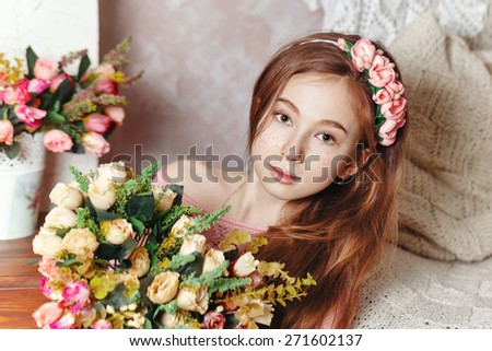 Beautiful teen girl with a bouquet of spring flowers in home interior. The concept of a happy childhood.