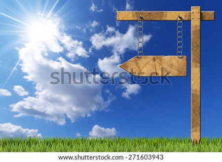 Wooden Directional Sign - One Arrow with Chain. Wooden directional sign with one empty arrow hanging with metal chain on a wooden pole on blue sky with clouds, sun rays and green grass