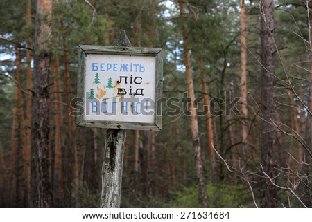 Information board in forest with message in Ukrainian: keep forest from fire