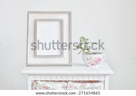 Home decoration, picture frame and plant on the bedside table