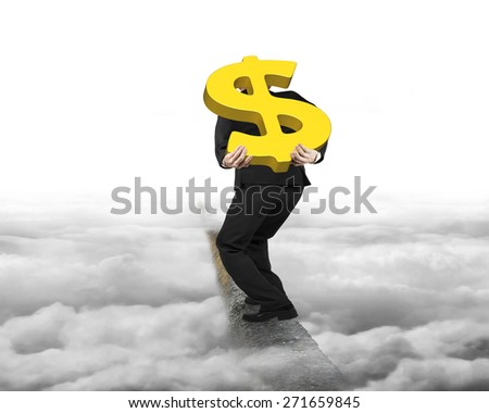 Businessman carrying big 3D gold dollar sign balancing on concrete ridge with gray cloudy sky background