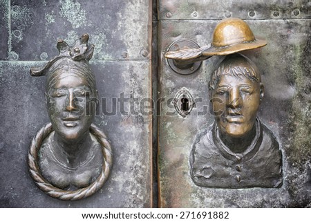Door made of bronze with the head of a woman and a man as a door knob in Magdeburg, Germany