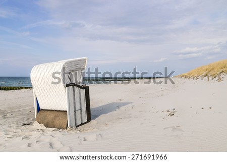 Picture of a beach chair on the Baltic Sea beach with dune grass and sea in the background