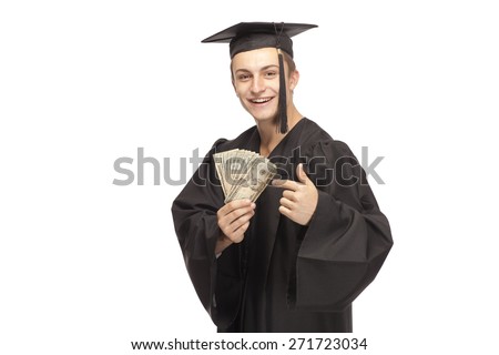 Portrait of happy young man in graduation gown with fanned money against white background