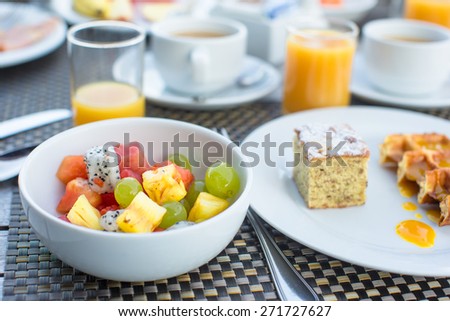Fresh fruit salad, waffles, cake, coffee and juice served for breakfast at resort restaurant