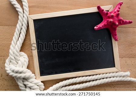 Closeup toned photo of empty blackboard with starfish and marine knot