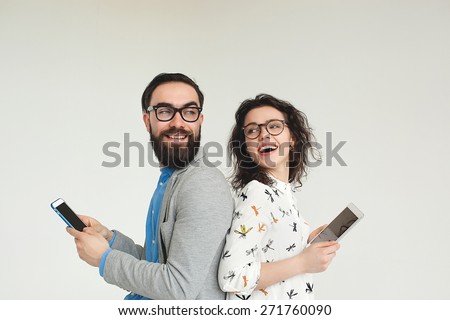 Young hipster man and woman in glasses with smartphone and tablet isolated on the blank white background