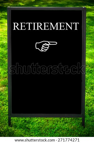 RETIREMENT message and hand pointing to the right on sidewalk blackboard sign against green grass background. Copy Space available. Concept image