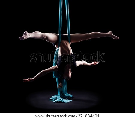 Young woman gymnast with blue gymnastic ribbon isolated on black