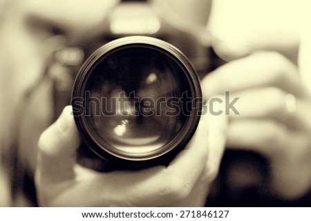 photographer with camera in hand looking through the camera lens Royalty-Free Stock Photo #271846127