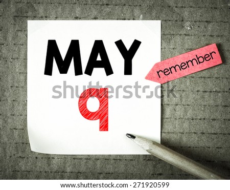 Note with 9 may and pencil on grunge background