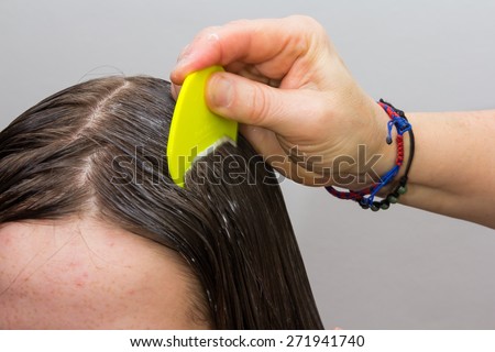 Girls hair being examined and cleaned for lice