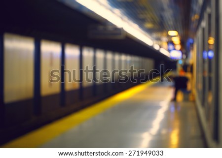 Blurred blurry soft focus background, interior of subway metro underground with passengers on a platform waiting 