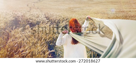 panoramic picture of walking red hair woman by the plain field, lifestyle travel concept