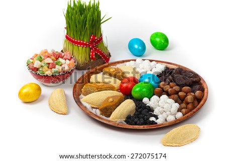 Novruz in Azerbaijan. Colored eggs for easter and traditional sweets on white background. Selective focus.