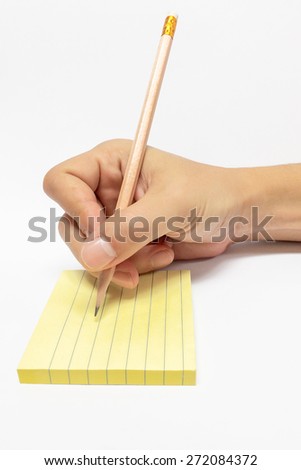 Male Hand with Pencil Writing in Yellow Sticky Notebook with Line