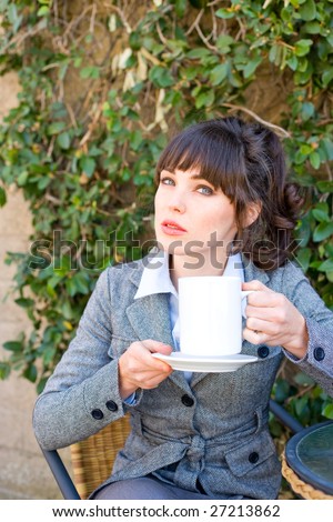 Attractive young business woman drinking coffee at outdoor cafe